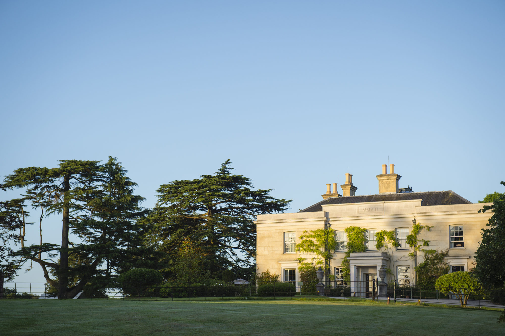 The Limewood Hotel exterior surrounded by large trees and blue skies