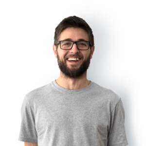 A bearded man with short dark hair and black rimmed glasses